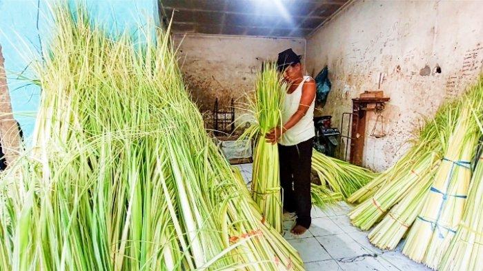 Dani, salah satu penjual janur dibantu seorang pelayan di Pasar Sidoarjo sedang menyortir janur sebelum di ikat sebelum dijual, Jumat (12/4/2024)