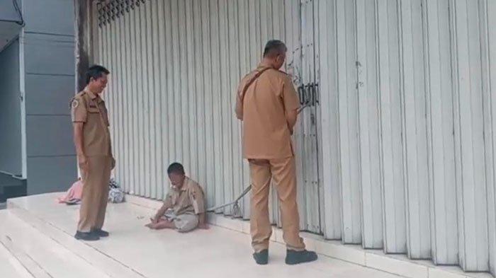 Petugas Dinkes Tulungagung melepas tali di tubuh Au (14), seorang anak ODGJ yang diikat ibunya, Rs (54) sesama ODGJ di Jalan Teuku Umar, Tulungagung, Senin (20/1/2025).