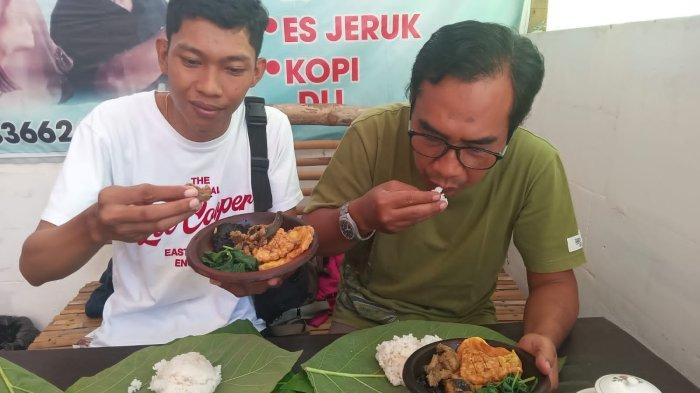 Dua pengunjung asal Kota Madiun tengah melahap Gombelwakcukdongti, alias Sego Sambel Kluwak Pincuk Godhong Jati buatan Sri Martini, Desa Sirapan, Kecamatan/Kabupaten Madiun, Jumat (12/4/2024).
