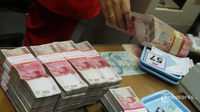 UANG KORUPSI RUGIKAN NEGARA - Ilustrasi uang yang dihitung oleh seorang pegawai bank. Seorang pria menjadi buron kurang lebih 11 tahun setelah rugikan negara ratusan juta.