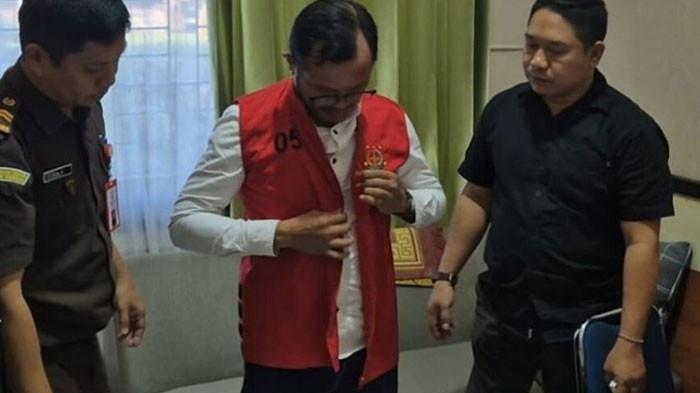 KADES KORUPSI MILIARAN - LOI, Kepala Desa Amolengu, Kecamatan Timur, Kabupaten Konawe Selatan, Sulawesi Tenggara, memakai rompi orange saat hendak ditahan oleh Kejari Konawe Selatan.