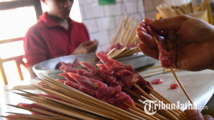 Karyawan menusukan sate daging kambing di Warung Sate Bang Saleh, Kota Malang, Minggu (16/6/2024).