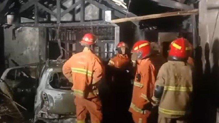 Petugas pemadam kebakaran Dinas Pemadam Kebakaran dan Penyelamatan Surabaya melakukan pembasahan di lokasi kebakarabn rumah di Jalan Raya Tengger Surabaya, Sabtu (21/9/2024) sore.