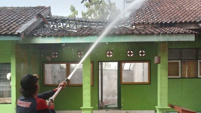 Petugas sedang memadamkan api di gedung perpustakaan SDN Pelem 2, Desa Pelem, Kecamatan Pare, Jumat (8/11/2024).