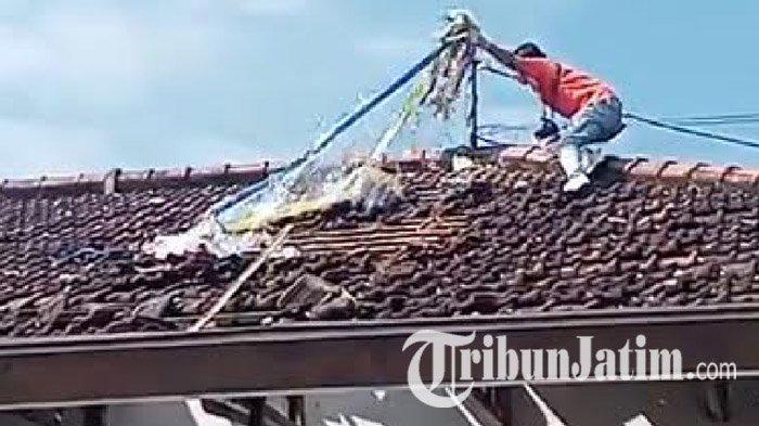 SISA BALON UDARA - Kepala Unit Inafis Satreskrim Polres Tulungagung, Aiptu Sugapri mengambil sisa plastik balon udara dan tali-temali bekas untaian petasan dari atap rumah Marsini (59) yang rusak parah di Desa Suruhanlor, Kecamatan Bandung, Kabupaten Tulungagung, Jawa Timur, Minggu (13/4/2025) pagi. Sebelumnya sebuah petasan ukuran besar jatuh dari balon udara, dan menimbulkan kerusakan parah.