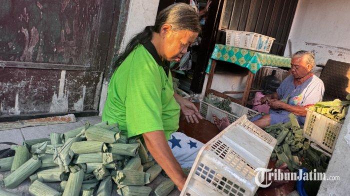 KAMPUNG LONTONG DI SURABAYA - Kesibukan warga di Kampung Lontong Jalan Banyuurip Lor Gang X Surabaya yang tengah menata gulungan lontong mentah dan menggunting tepian gulungan daun lontong, Selasa (1/7/2025). Pemandangan lumrah ini dapat ditemui di sejumlah rumah di kampung tersebut, sebagai pusat produksi aktif lontong di Surabaya.