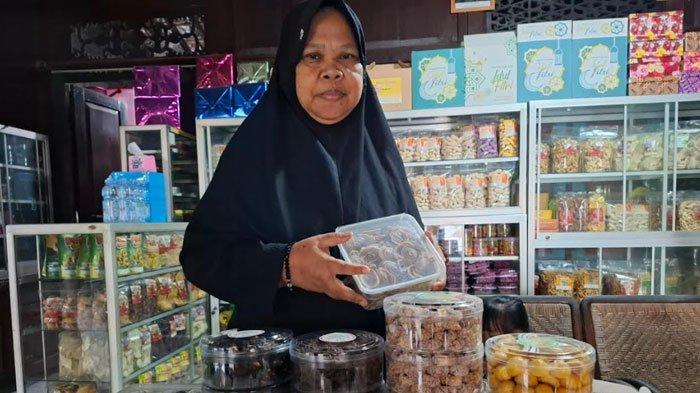 LARIS MANIS - Pinisri (50), perajin kue kering asal Desa Sragi, Kecamatan Songgon, Banyuwangi menata dagangannya. Ia kebanjiran pesanan menjelang Lebaran.