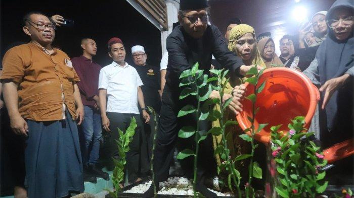 Mahfud MD saat menyiram air bunga di atas kuburan Ibundanya, Siti Khadijah di TPU Dusun Seccang, Desa Plakpak, Kecamatan Pegantenan, Kabupaten Pamekasan, Madura, Jumat (17/1/2025).