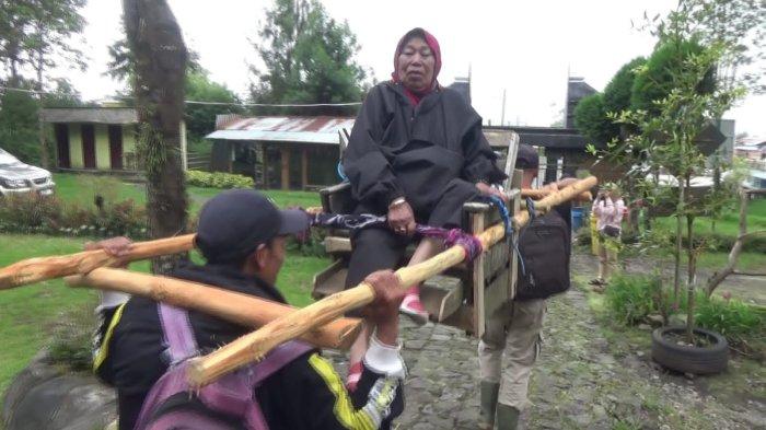 Mbok Yem saat ditandu oleh dua orang menuruni Puncak Gunung Lawu demi pulang kampung Hari Raya Idul Fitri