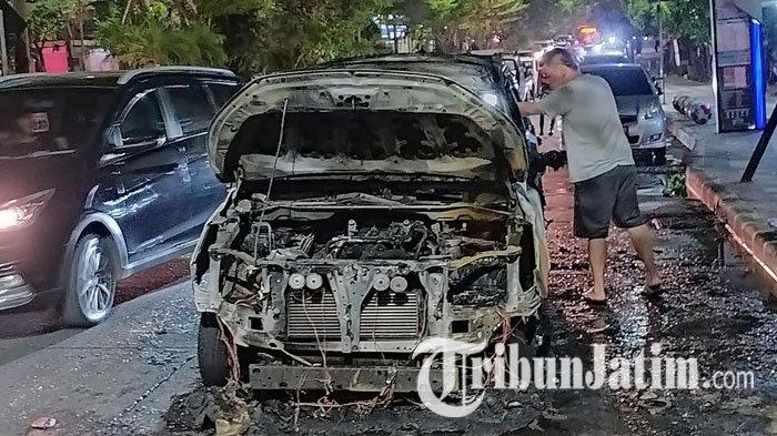 Mobil Toyota Innova bernopol W-1810-AV yang ditumpangi dua sejoli terbakar di Jalan Mayjend Sungkono, Pakis, Sawahan, Surabaya, Sabtu (11/11/2023).