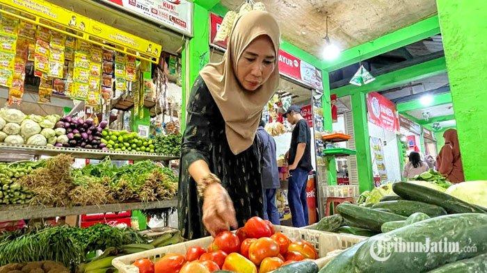 Mustika, pedagang sayur Pasar Sawojajar, Kota Malang menata dagangan sayur tomat, Jumat (1/11/2024) dalam artikel berjudul 