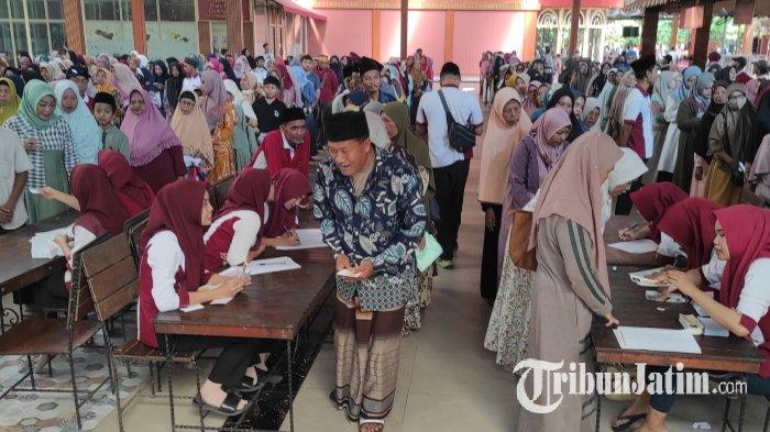 Para jemaah pengajian rutin sabtu pagi antre mengambil uang THR di tempat wisata edukasi Kampung Coklat, Kabupaten Blitar, Sabtu (30/3/2024).
