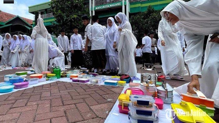 Para siswa-siswi Madrasah Aliyah Negeri (MAN) 1 Kota Malang saat memperingati Hari Santri Nasional (HSN) 2024 dengan tajuk 'Kenduri Cinta Santri 1000 Rantang' di halaman sekolah MAN 1 Kota Malang, Senin (21/10/2024).