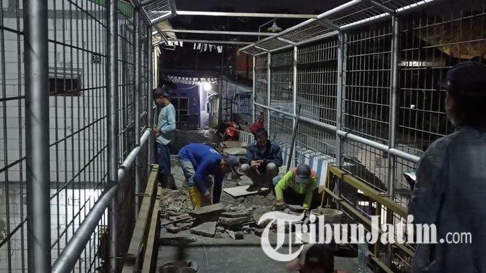 Pekerja sedang memperbaiki sisi Jembatan Pelor Malang yang rusak, Kamis (28/9/2023) malam.