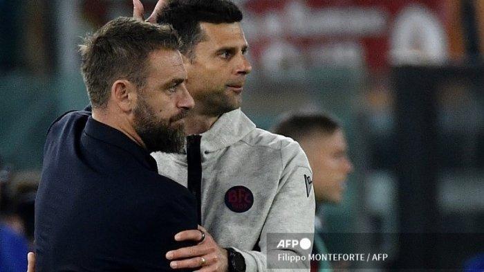 DI UJUNG TANDUK - Pelatih Roma asal Italia Daniele De Rossi (kiri) memberikan pelukan kepada pelatih Bologna, Thiago Motta di penghujung pertandingan sepak bola Serie A Italia Roma vs Bologna di stadion Olimpiade di Roma pada 22 April 2024. (Foto arsip April 2024). Thiago Motta kini terancam tergantikan di kursi pelatih Juventus. (Filippo MONTEFORTE / AFP)