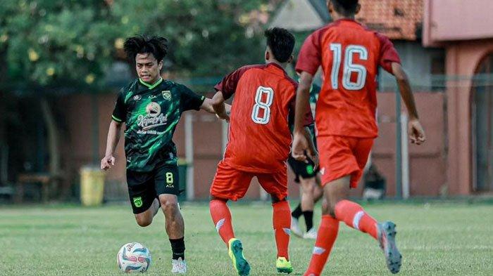 Pemain Persebaya Surabaya (kaus hijau) diadang pemain Tim PON Jatim di Lapangan Thor, Surabaya, Sabtu (6/7/2024) sore. Laga uji coba ini berakhir dengan skor 5-0 untuk Persebaya.