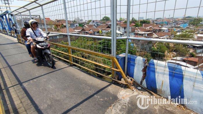 Pengendara saat melintas di jembatan Pelor Kota Malang jalur penghubung alternatif antara Kelurahan Samaan dan Kelurahan Oro Oro Dowo pada Kamis (28/9/2023). Diketahui, jembatan tersebut mengalami keretakan tepatnya di bagian sisi selatan, membuat pengendara yang melintas dan warga khawatir.