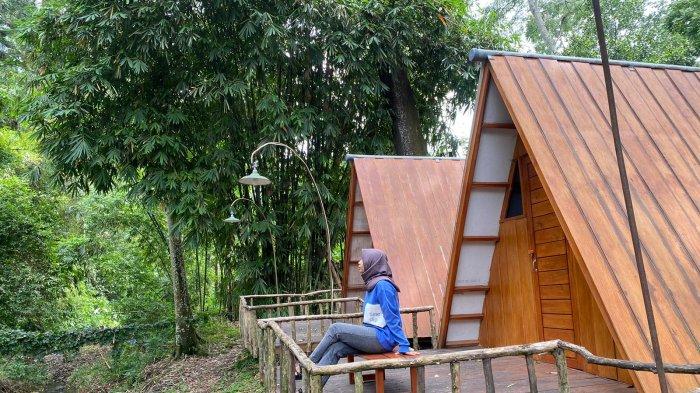 Pengunjung menikmati suasana teduh di depan tenda kerucut di pinggiran aliran sungai Teduh Glamping.