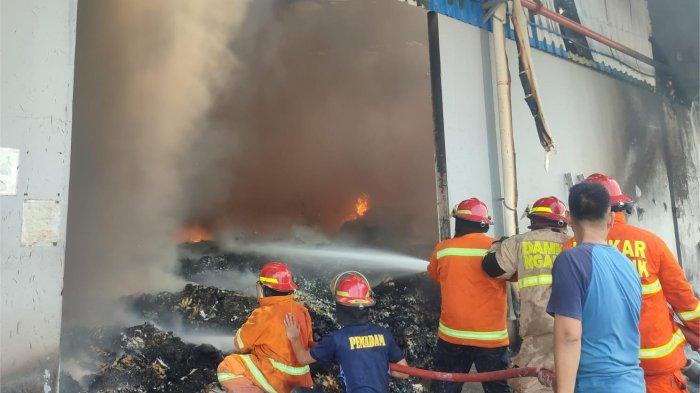 Personel Damkar Kabupaten Nganjuk berjibaku memadamkan api yang melumat gudang PT SAI, Sabtu (7/9/2024). 
