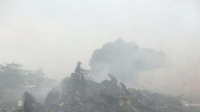 Petugas PMK saat berusaha memadamkan api yang membakar gudang rongsokan di Sidoarjo pada Selasa, (15/10/2024).