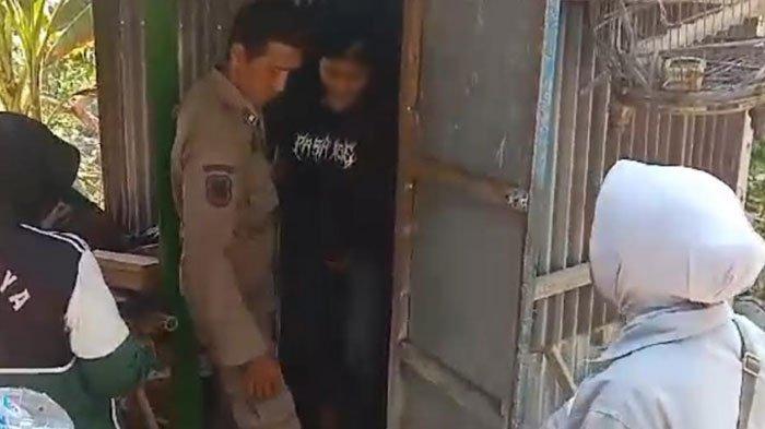 Petugas Satpol PP Bangkalan melakukan pendekatan persuasif untuk meminta seorang anak perempuan di bawah umur keluar dari kamar mandi setelah berupaya menghindari razia di simpang empat akses Suramadu, Desa Petapan, Kecamatan Tragah, Kamis (19/9/2024).