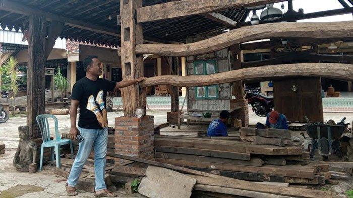 PENJUAL BARANG ANTIK - Suwanto memeriksa salah satu koleksi kandang kebo (kerbau) miliknya yang ada di Desa Tawing, Kecamatan Gondang, Kabupaten Tulungagung, Jawa Timur, Senin (3/2/2025). Polisi berpangkat Brigadir Kepala ini menjual kandang kebo kuno ini hingga ke Amerika Serikat, Singapura, Timur Tengah dan berbagai wilayah di Indonesia.