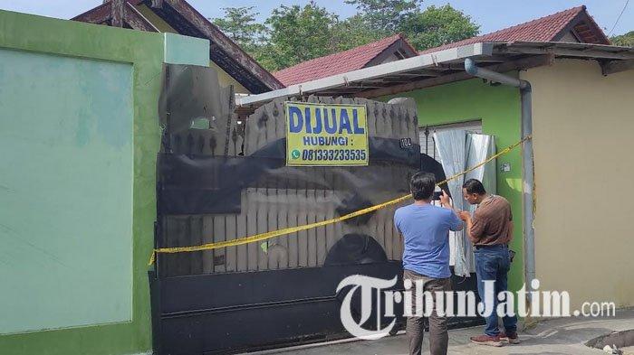 Polisi memasang garis polisi di lokasi penemuan 2 jasad membusuk di rumah, Jalan Sulawesi, Kota Blitar, Selasa (2/1/2024).