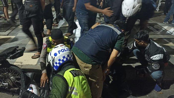 Polisi mengevakuasi dua korban ditabrak pengendara sepeda motor yang hindari razia, Minggu (10/9) dini hari