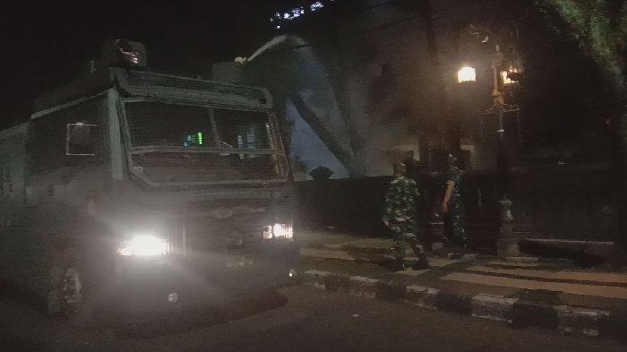TERBAKAR - Pos jaga gedung DPRD Kota Malang yang dibakar oleh massa aksi saat dipadamkan oleh mobil water canon Polresta Malang Kota, Minggu (23/3/2025) malam. Diketahui, awalnya demo tolak UU TNI yang dilakukan massa Arek-Arek Malang Turun Ke Jalan berjalan damai, namun belakangan menjadi ricuh hingga harus dibubarkan.
