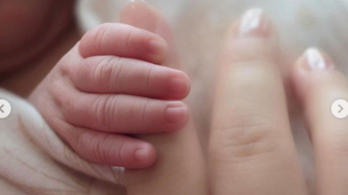 Potret Syahrini memegang tangan baby R.