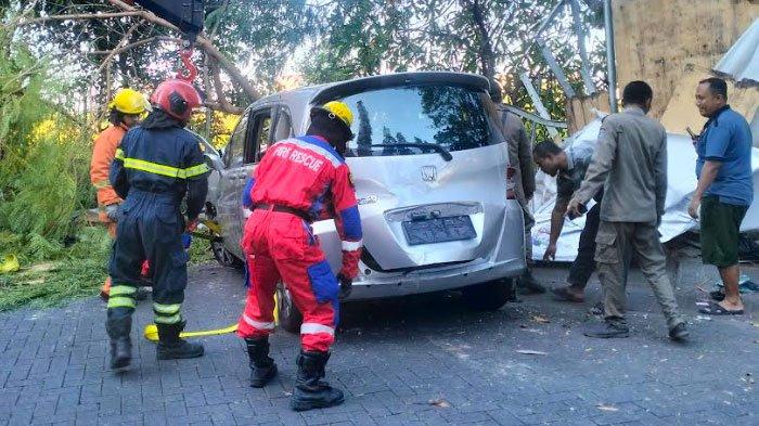 Regu penyelamat mengevakuasi mobil ITS yang kecelakaan di seberang Apartemen Kertajaya Indah Regency Surabaya, pada Rabu (23/8)
