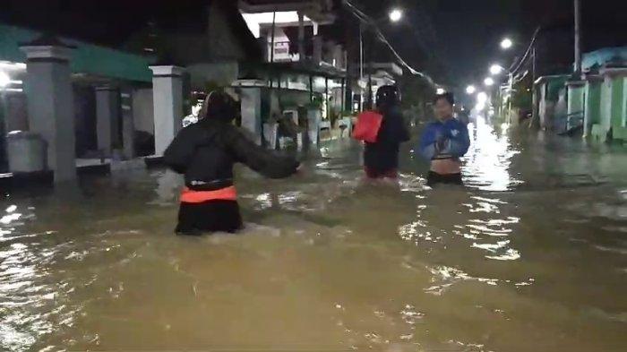 BANJIR GRESIK - Aktivitas warga di Desa Munggugianti, Kecamatan Benjeng, Selasa (25/2/2025) malam. Ribuan rumah di Gresik tercatat terdampak banjir