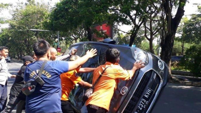 Saat petugas kepolisian, DPKP, Dishub, BPBD, dan Satpol PP Kota Surabaya membantu mengevakuasi mobil korban dengan cara mendorongnya sebagai manual