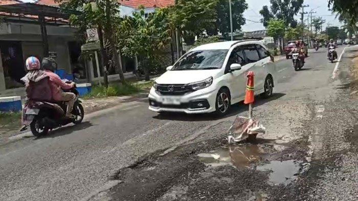 JALAN NASIONAL RUSAK: Salah satu ruas Jalan Raya Bancaran Bangkalan semakin menyempit karena sisi jalan rusak parah karena kerap tergerus air hujan, Rabu (12/2/2025). Kondisi memprihatinkan jalan nasional itu berulang kali memakan korban pengendara sepeda motor karena jatuh  setelah terjerembab lubang
