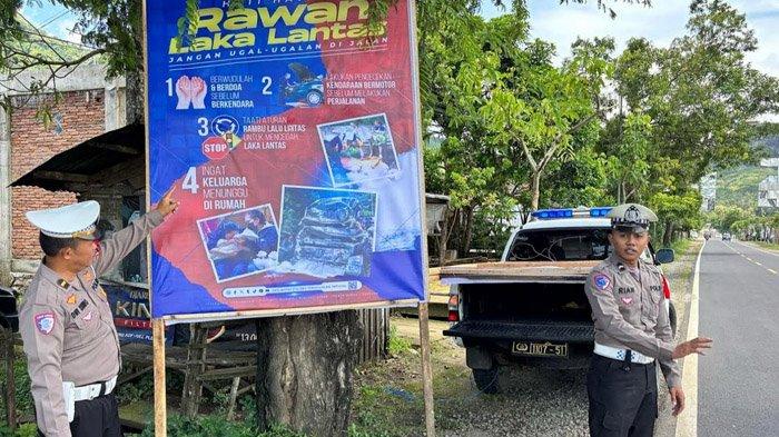 BALIHO - Satlantas Polres Trenggalek memasang baliho peringatan jalur rawan kecelakaan lalu lintas dan edukasi tertib pengendara, Sabtu (22/3/2025). Jalan Nasional Trenggalek-Tulungagung di Kecamatan Durenan menjadi salah satu ruas rawan kecelakaan lalu lintas.