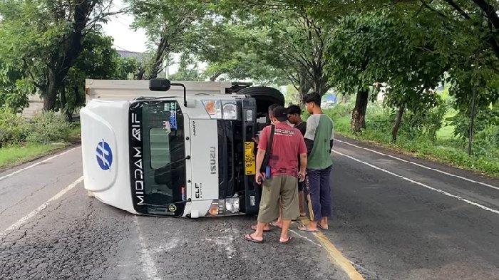 Sebuah truk boks paket nopol W 8369 UK terguling hingga berbalik arah di Jalan Raya Ring Road, masuk Desa Klitik, Kecamatan Geneng, Kabupaten Ngawi, Jawa Timur, Selasa (12/11/2024).