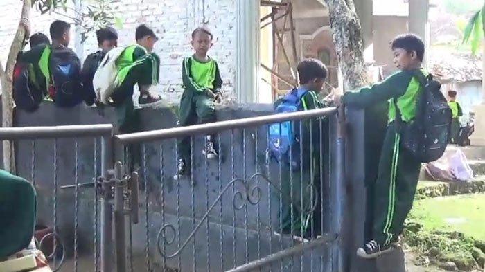 Sejumlah siswa SD Negeri 2 Buddan, Kecamatan Tanah Merah, Kabupaten Bangkalan terpaksa memanjati tembok akibat gerbang sekolah digembok, Jumat (29/11/2024).