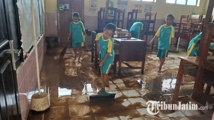 Siswa Siswi SDN Ngadirejo 2, Kecamatan Wonoasri, Kabupaten Madiun, tengah kerja bakti membersihkan sisa material banjir berupa air dan lumpur, yang merendam sejumlah kelas dan ruang guru, Jumat pagi (6/12/2024)