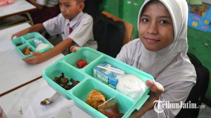 Siswa menunjukan menu saat pelaksanaan program Makan Bergizi Gratis (MBG) di SDN Lowokwaru 3 Kota Malang, Jawa Timur, Senin (13/1/2025).