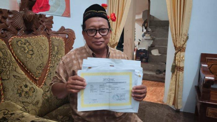 Sukono, adik almarhumah Hj. Kasima salah satu korban dugaan penipuan dan penggelapan dana koperasi simpan pinjam menunjukkan surat warkat.