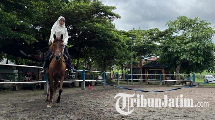 Seorang pengunjung mencoba mengendarai kuda di Wisata Berkuda Sumber Tawang Stable Horse Riding yang berlokasi di Jalan Cisadane No 99, Sumberbendo, Kecamatan Pare, Kabupaten Kediri, Rabu (29/1/2025).