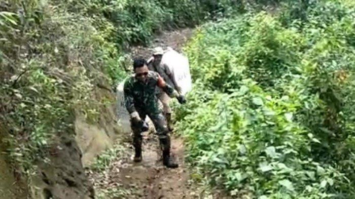 Tangkapan layar video tim pengantar logistik Pilkada yang dipikul saat berjalam kaki di medan curam Bondowoso