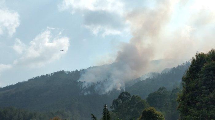 Pantauan dari jarak jauh terlihat Helikopter Water Bombing menjatuhkan bom air ke titik api Karhutla Gunung Lawu wilayah Kabupaten Magetan, Sabtu (7/10/2023).