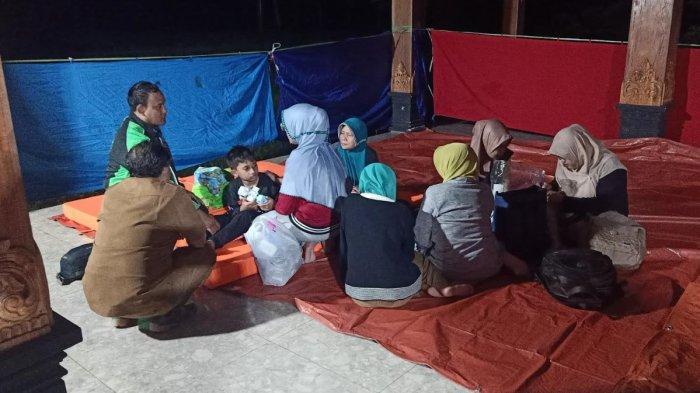LONGSOR - Warga Desa Depok, Kecamatan Bendungan, Kabupaten Trenggalek, Jawa Timur mengungsi di posko tanah longsor Desa Depok, Senin (19/5/2025). Sebanyak 6 orang dalam pencarian akibat bencana tanah longsor.