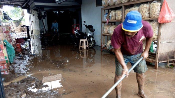 Warga Desa Joho, Kecamatan Kalidawir Tulungagung membersihkan lumpur di dalam rumah, usai banjir bandang.