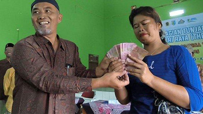 TANGIS HARU SUNIPAH - Tangis haru menyelimuti seorang ibu anak tujuh ketika menjadi penerima terbanyak tunjangan hari raya (THR) dari pemerintah Desa Wunut, Kecamatan Tulung, Kabupaten Klaten, Selasa (18/3/2025). Ribuan warga mendapat THR dari pemerintah desa, satu orang dapat Rp200 ribu.