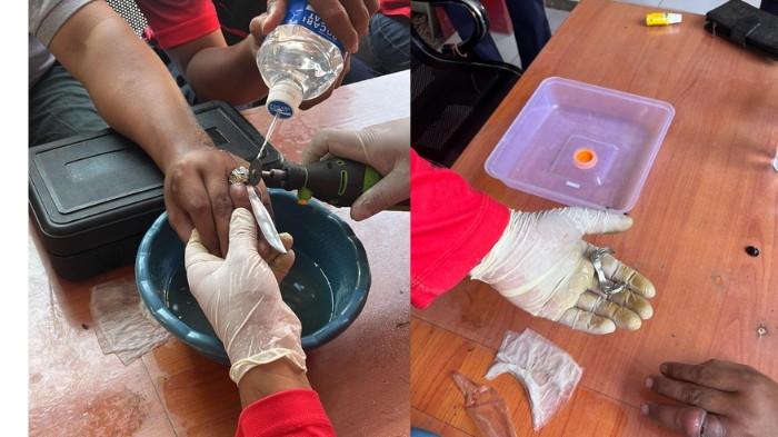 LEPAS CINCIN - Personel Damkar Kabupaten Nganjuk tengah berupaya melakukan pelepasan cincin dengan gerinda mini, kemarin. Cincin itu nyangkut dan bikin bengkak jari manis Anggoro (39) warga Desa Sonopatik Kecamatan Berbek, Kabupaten Nganjuk. 