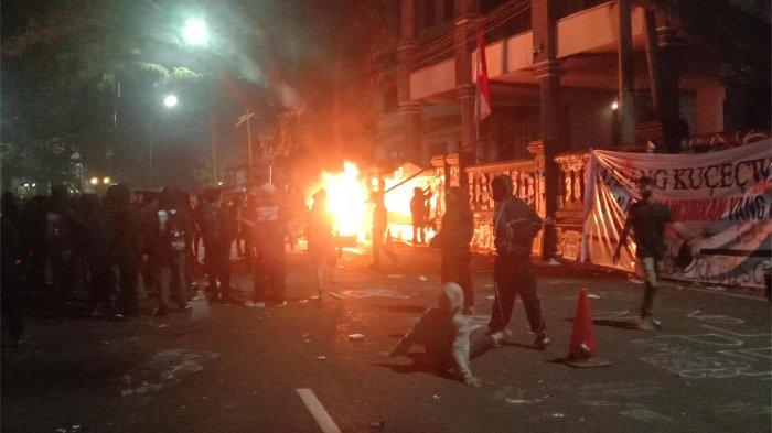 AKSI TOLAK UU TNI - Massa Arek-Arek Malang Turun Ke Jalan saat menggelar aksi demo tolak UU TNI depan Gedung DPRD Kota Malang, Minggu (23/3/2025). Hingga memasuki malam hari, aksi massa makin ricuh.