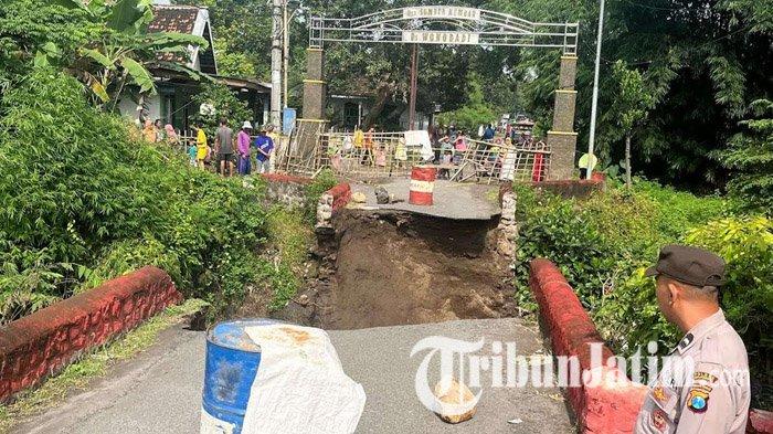 JEMBATAN PUTUS - Kondisi jembatan di Dusun Sumberkembar, Desa Wonodadi, Kecamatan Kutorejo, Mojokerto, yang terputus akibat diterjang luapan aliran sungai saat hujan lebat di wilayah Kabupaten Mojokerto, Minggu (16/3/2025). Pemkab Mojokerto segera bangun jembatan darurat.