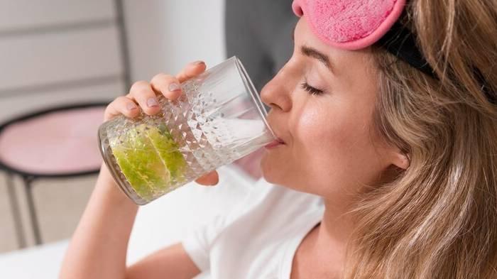 Ilustrasi seorang wanita meminum air detoks.